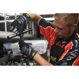 A mechanic wearing protective gloves works on automotive equipment.