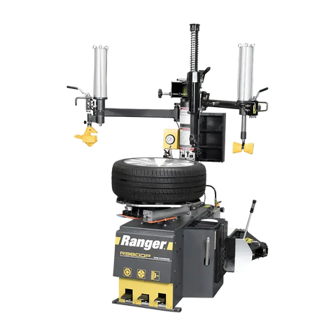 Gray and yellow Ranger R980DP tire changer with mounted tire, featuring pneumatic cylinders and dual assist arms