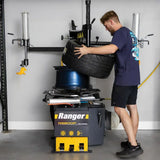 Man using Ranger R980DP Tire Changer with pneumatic cylinders to mount a tire on a wheel